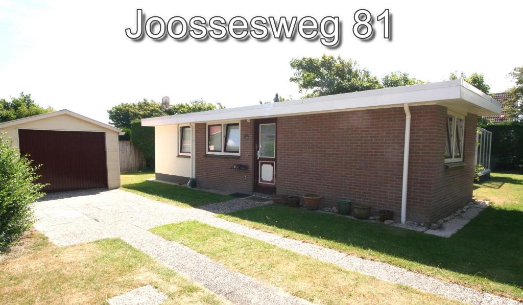 una pequeña casa de ladrillo con garaje en Joossesweg 81 en Westkapelle