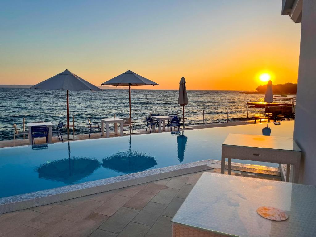 - une piscine avec vue sur l'océan au coucher du soleil dans l'établissement Luxury two-floor apartment in Petrčane with garden and pool, à Petrčane
