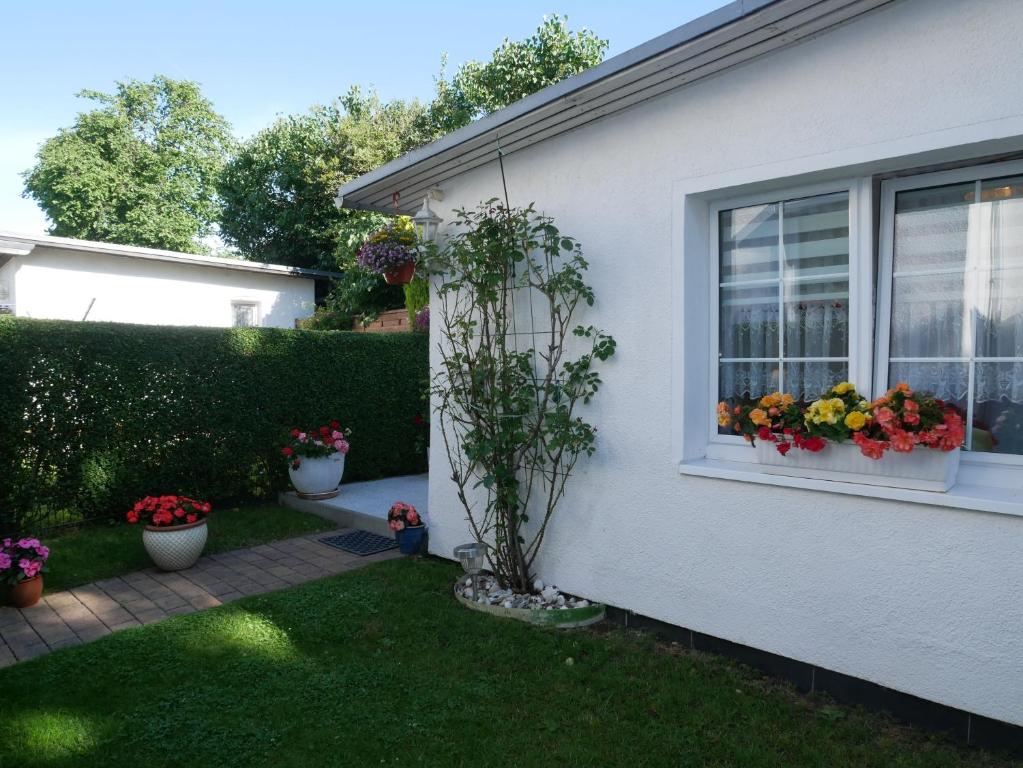 a house with a window with flowers in a yard at Bungalow Rarek "20 Gehmin vom Ostseestrand" in Gothen