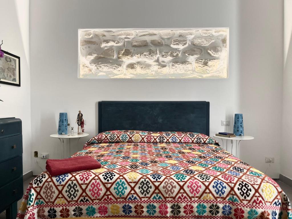 una camera da letto con un copriletto colorato di Casa Tancredi a Scicli