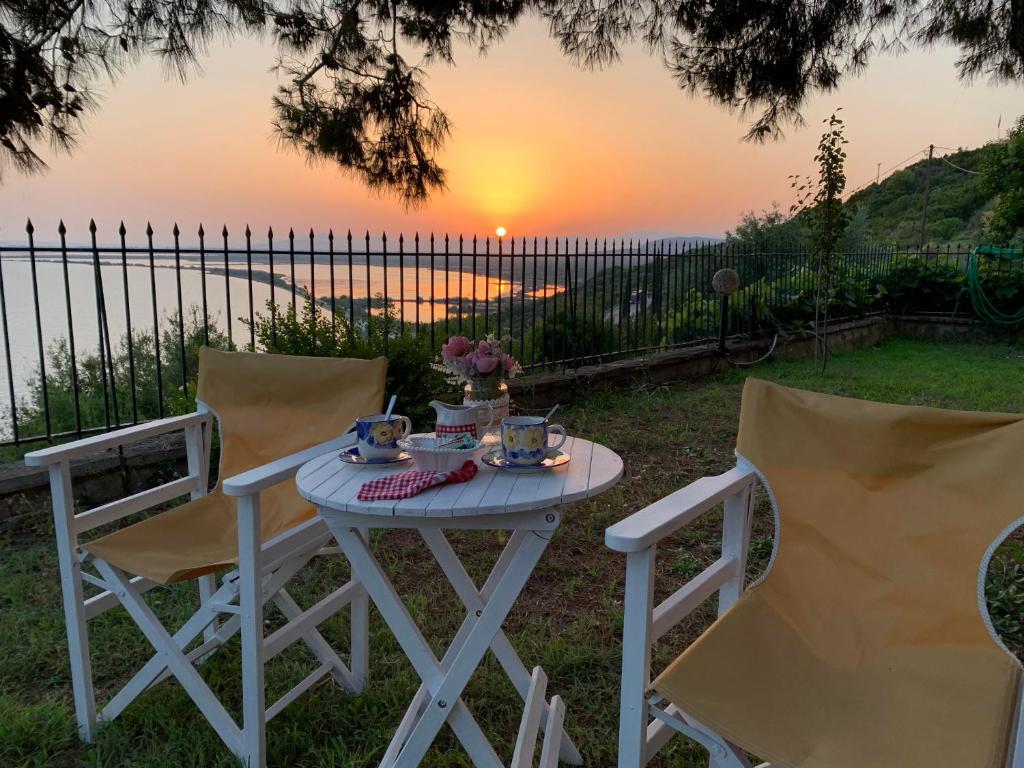 una mesa blanca con 2 sillas y una mesa con puesta de sol en Sunset Menidi Apartment, en Menídion