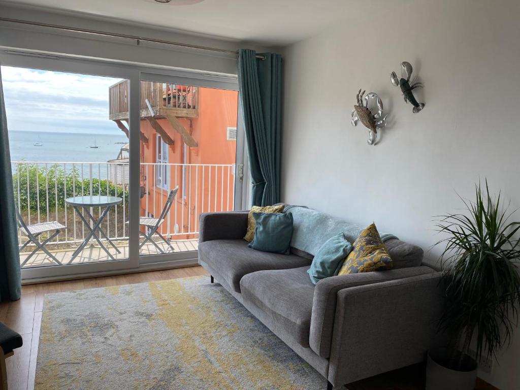 a living room with a couch and a view of the ocean at Vitamin Sea with a Sea View and Parking in Lyme Regis
