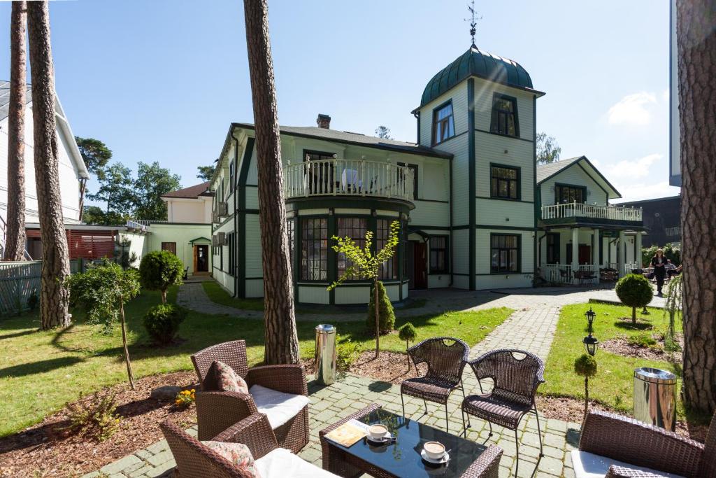 a large house with trees in front of it at Sunset Hotel in Jūrmala