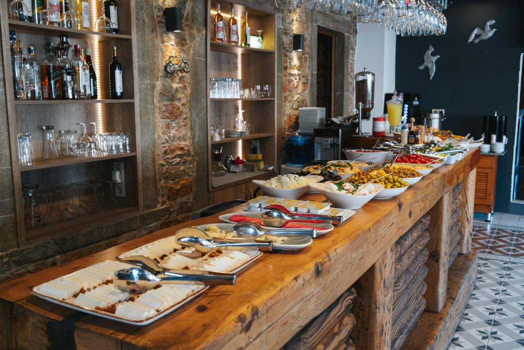 a buffet line with food on a wooden table at Akkan Hotel in Bodrum City