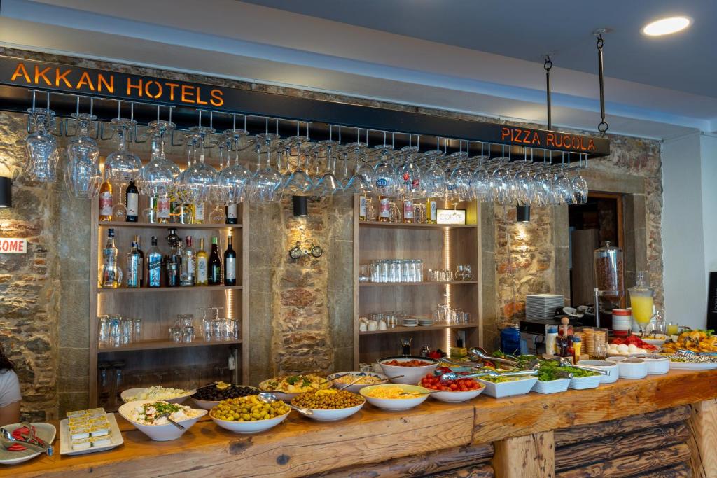 a buffet line with bowls of food and wine glasses at Akkan Hotel in Bodrum City