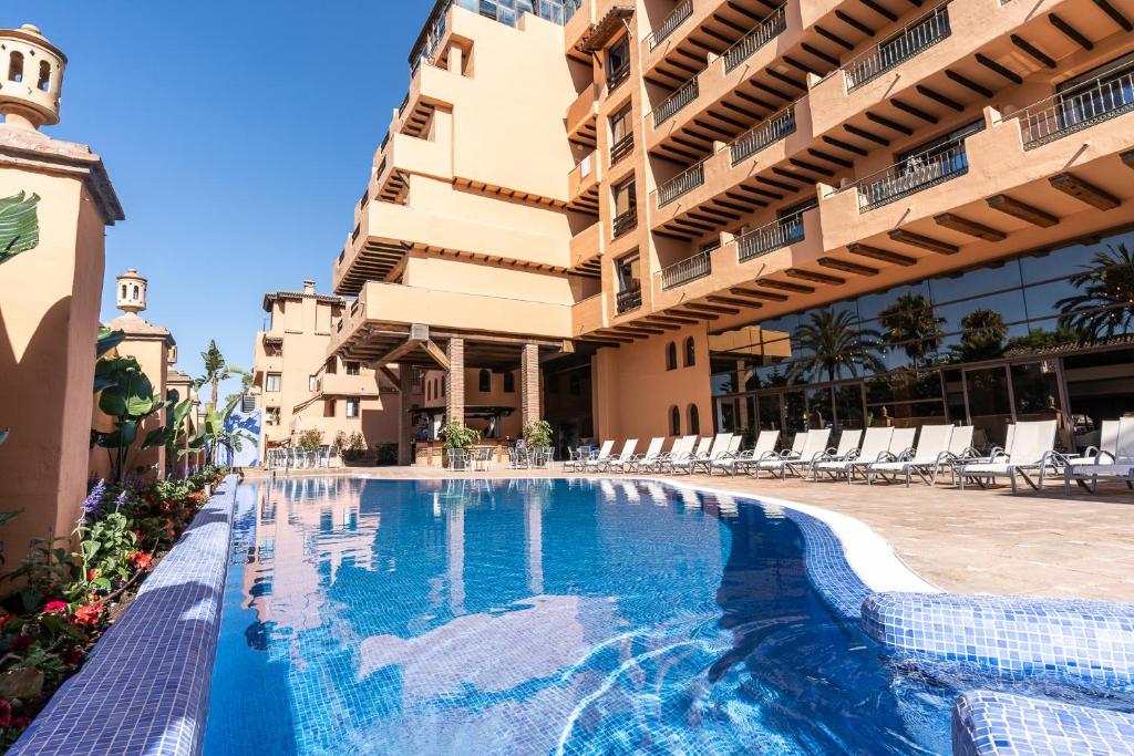 a swimming pool in front of a building at Globales Paraíso Beach in Estepona