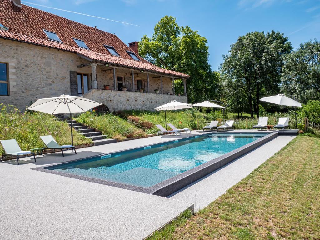 - une piscine avec des chaises et des parasols à côté d'une maison dans l'établissement VILLA MARCAUSI, à Lissac et Mouret
