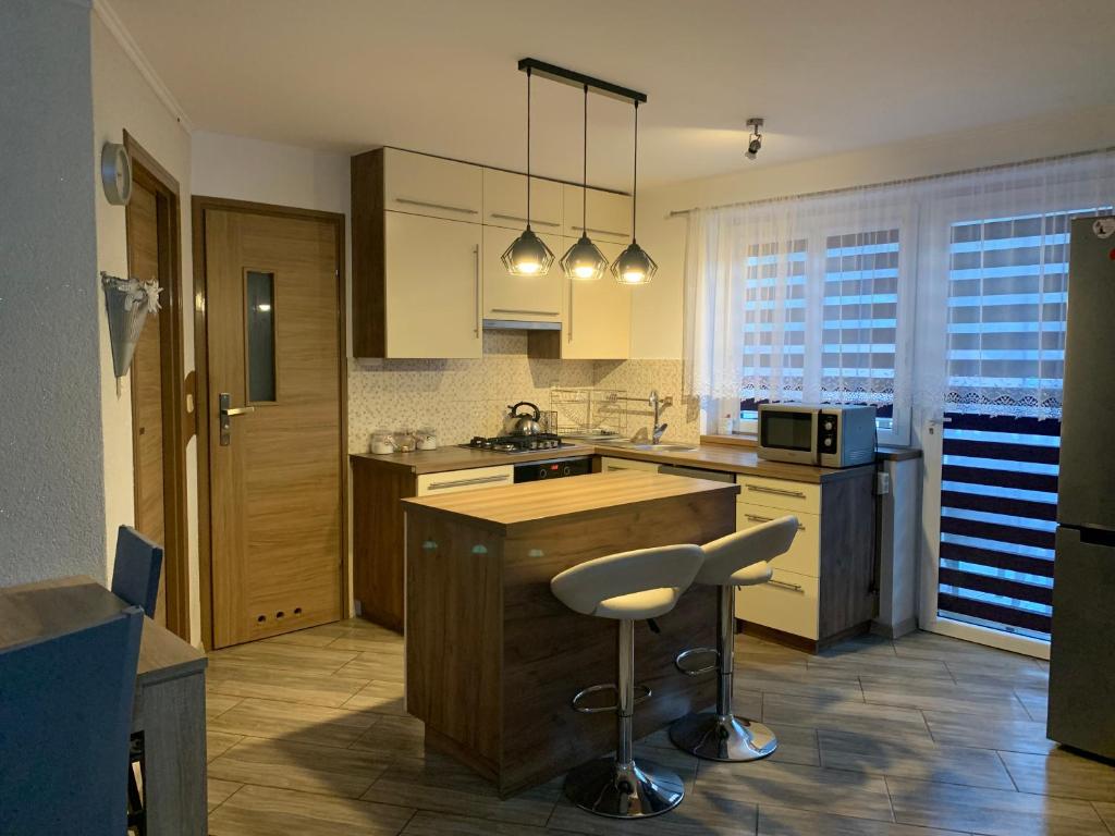 a kitchen with a counter and a bar stool in it at APARTMENT DOR-Ali u Ali in Żubracze