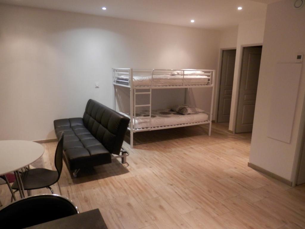 Pokój z kanapą i łóżkiem piętrowym w obiekcie CHALET INDIVIDUEL TRES ENSOLEILLE AU CALME VUE IMPRENABLE w mieście Saint-Étienne-de-Tinée
