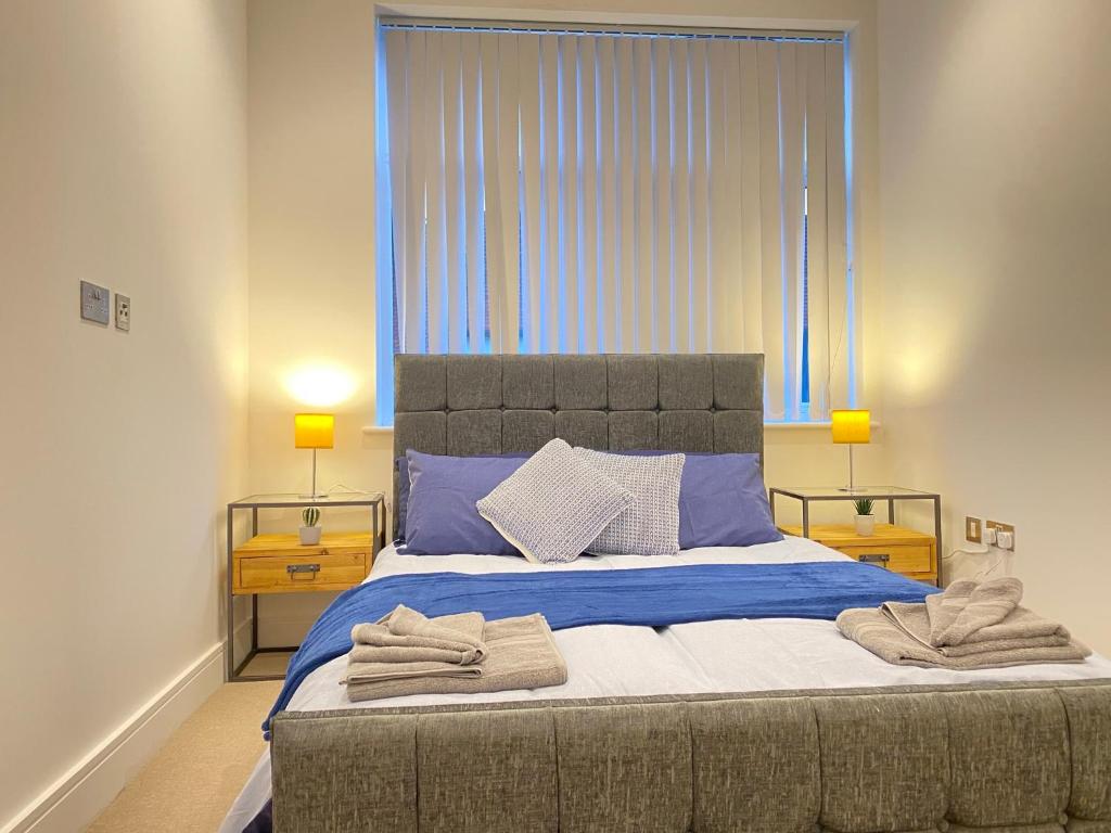 a bedroom with a large bed with towels on it at 10080 Luxury Apartment near Luton town Mall in Luton