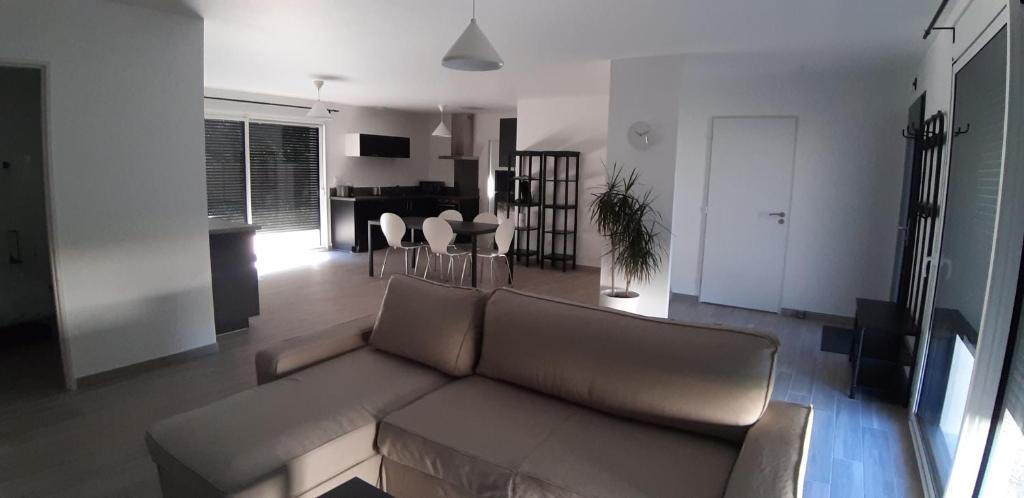 een woonkamer met een bank en een eetkamer bij Maison neuve 66 bis in Saint-Martin-la-Rivière