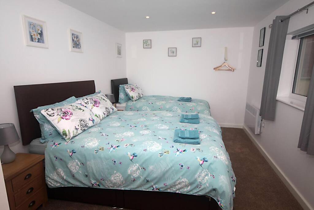 um quarto com uma cama com um edredão e almofadas azuis em No 28D St Benedict em Glastonbury