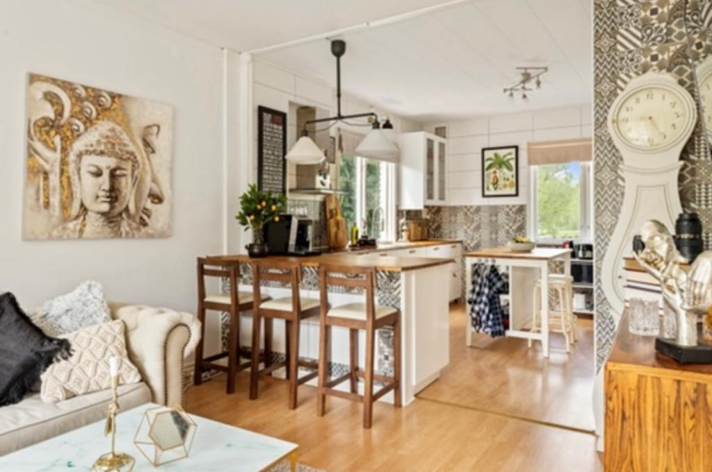 a kitchen and living room with a table and a clock at Beautiful Home in the Swedish landscape in Vissefjärda
