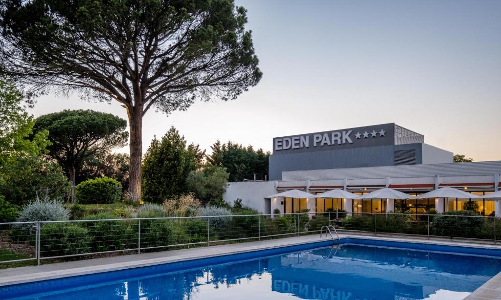 a swimming pool in front of a building at Hotel Eden Park by Brava Hoteles in Riudellots de la Selva