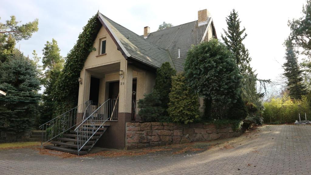 a house with a staircase in front of it at Ferienhaus mit Pool zum Träumen und Entspannen für alle Sinne in Bad Schmiedeberg