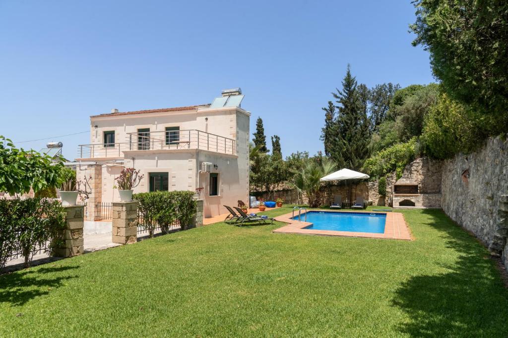 a house with a yard with a swimming pool at Villa Elia by PosarelliVillas in Vryses