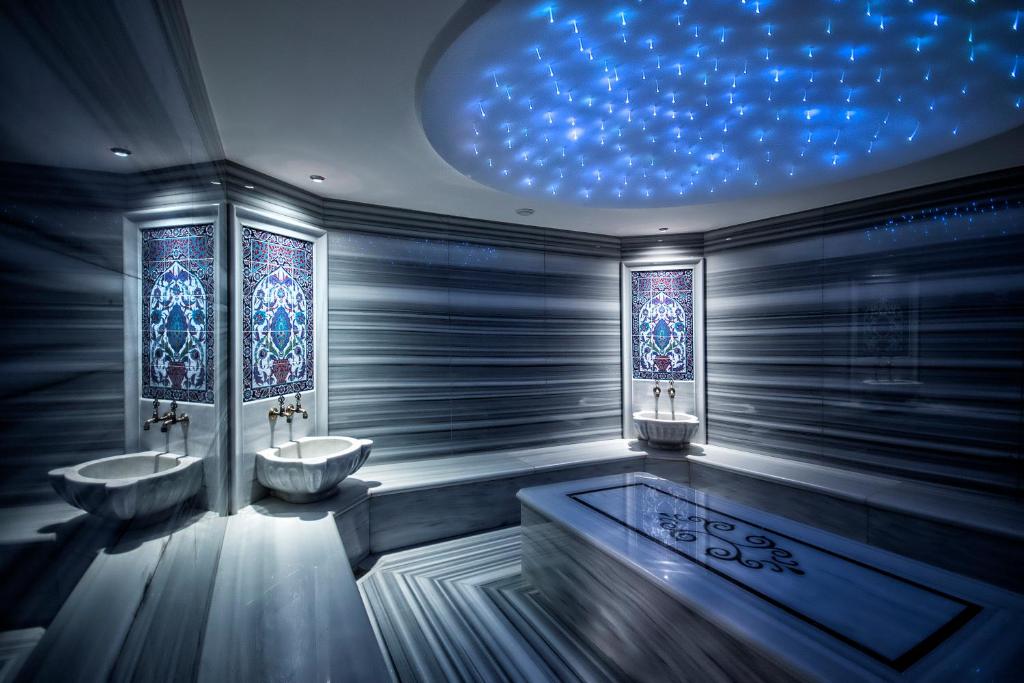 baño con 2 lavabos y techo azul en The Conforium Hotel İstanbul en Estambul