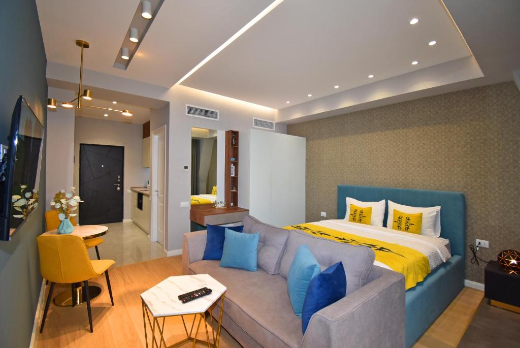 a bedroom with a couch and a bed with blue pillows at Yerevan4you NEW Studio Apartment in Yerevan