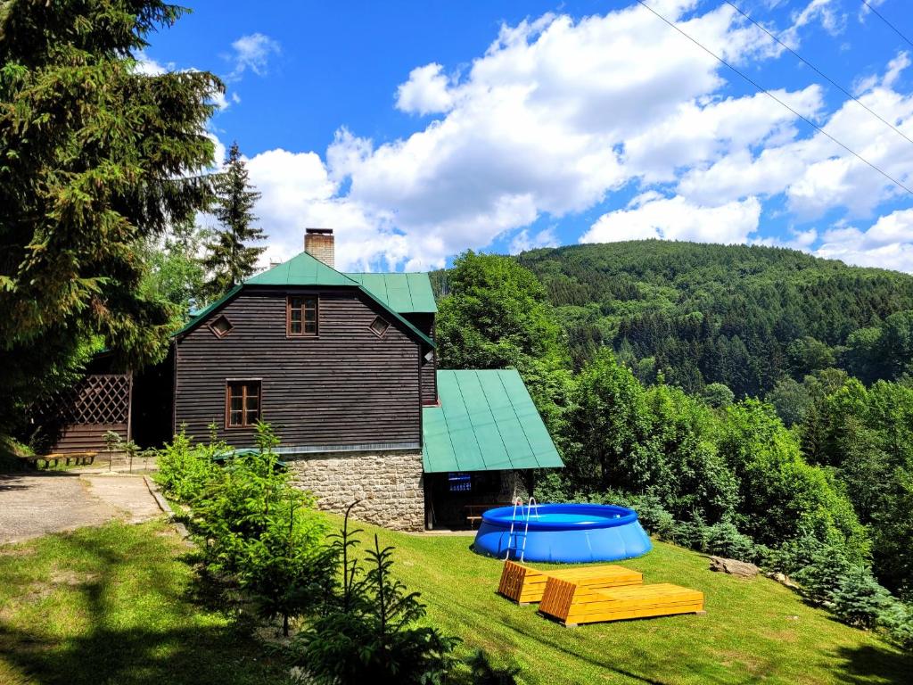 una casa con una estructura de juego en el patio en Horská chata Kouty en Loučná nad Desnou