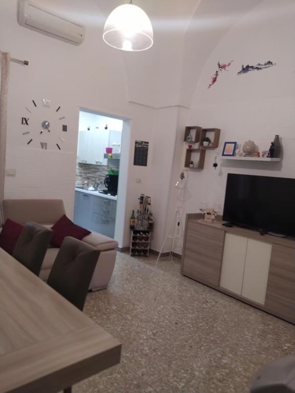 ein Wohnzimmer mit einem Sofa und einer Uhr an der Wand in der Unterkunft Marta's House in Novoli