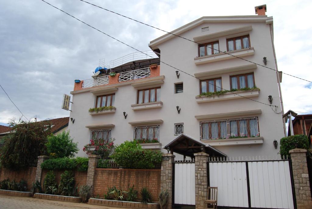 un edificio blanco con una valla delante en Antsirabe Hotel, en Antsirabe