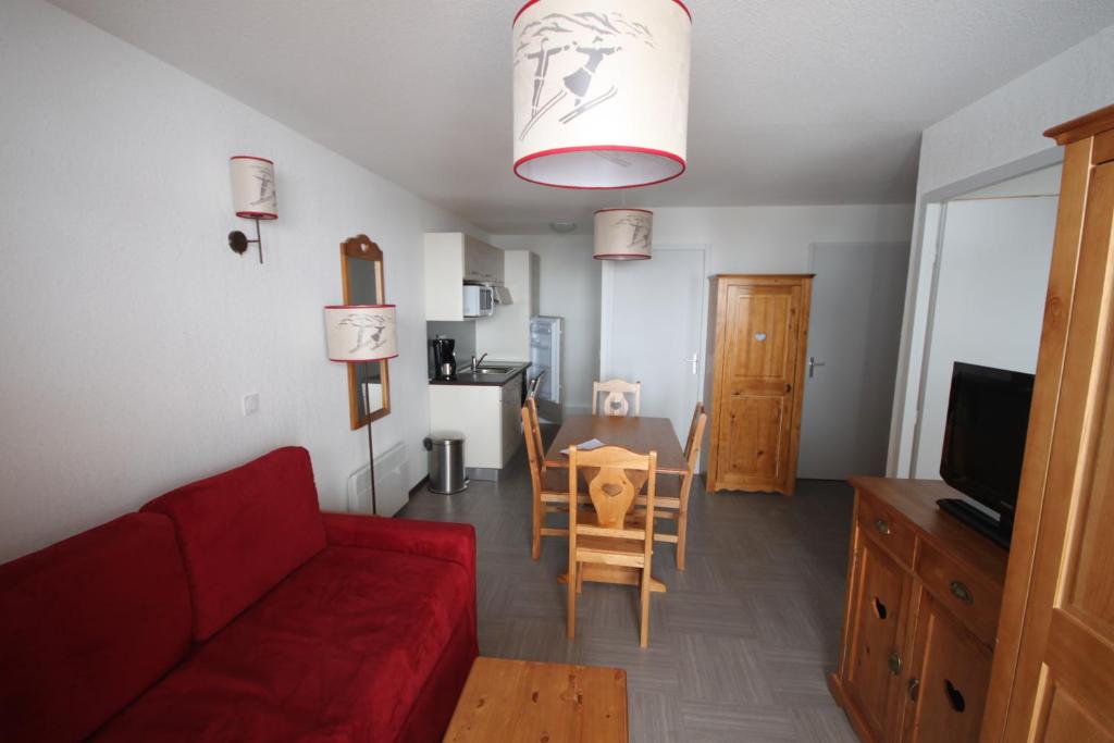 a living room with a red couch and a table at SNC Sainte Marie in Vars