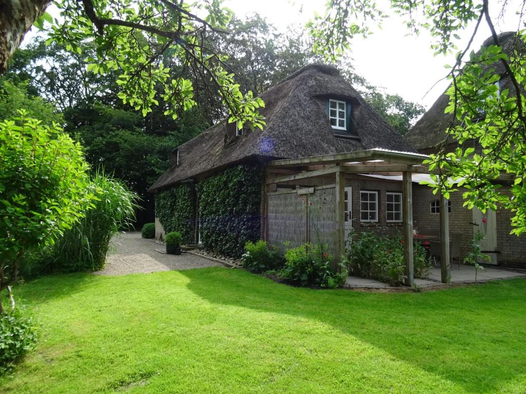 a house with a grass yard in front of it at Kleines Reethaus Johannsen in Silberstedt