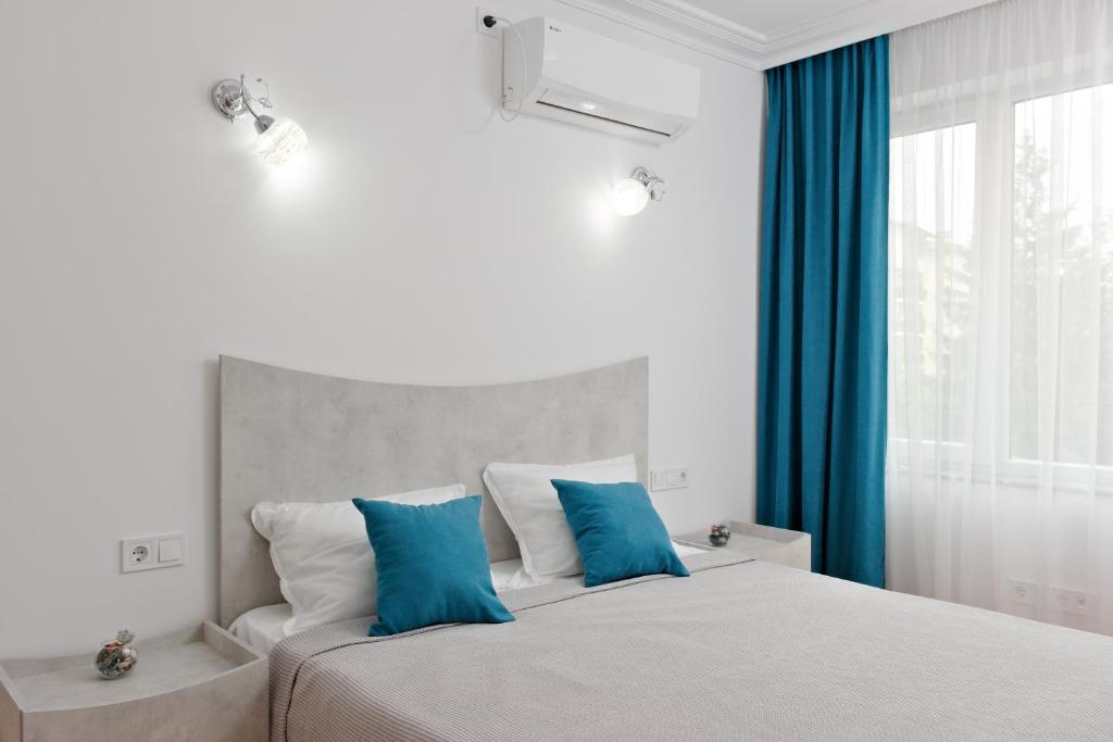 ein Schlafzimmer mit einem großen Bett mit blauen Kissen in der Unterkunft Апартамент за гости Дарива in Smoljan