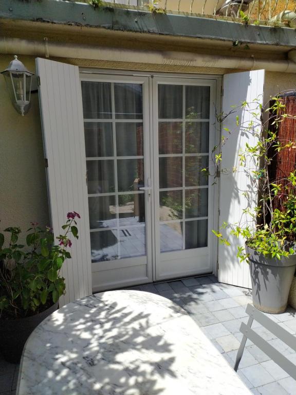 een glazen schuifdeur op een huis met planten bij Les pavés bleus - Cœur de Deauville in Deauville