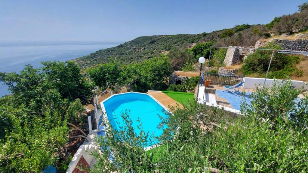 una piscina su una collina con l'oceano sullo sfondo di Il Giardino dei Tratturi - Con Splendida Vista sul mare e Piscina a Corsano