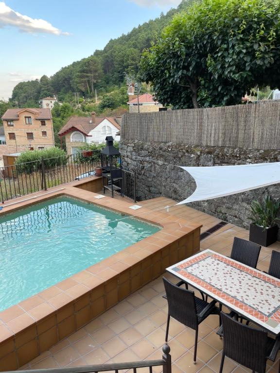 - une piscine avec une terrasse, une table et des chaises dans l'établissement La casa de las Flores de El Hornillo, à El Hornillo