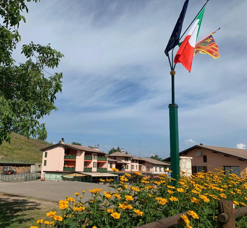 a flag on a pole in a field of flowers at Hotel Edelweiss in San Zeno di Montagna