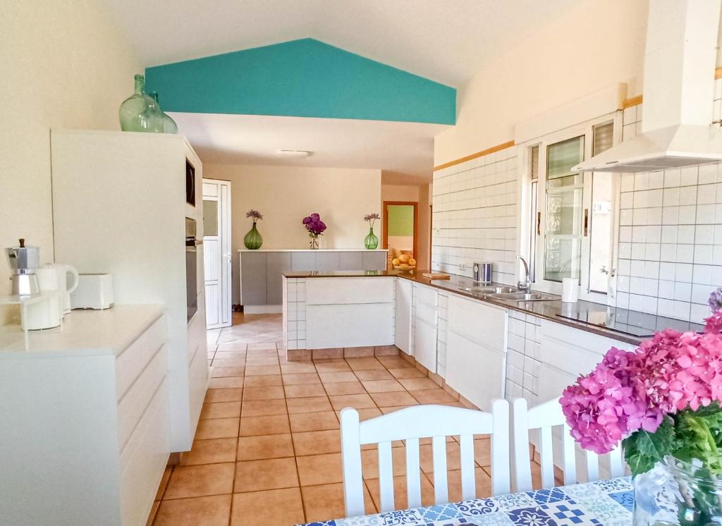 Una cocina con gabinetes blancos y un techo azul. en A casa da panadeira, en Cambados