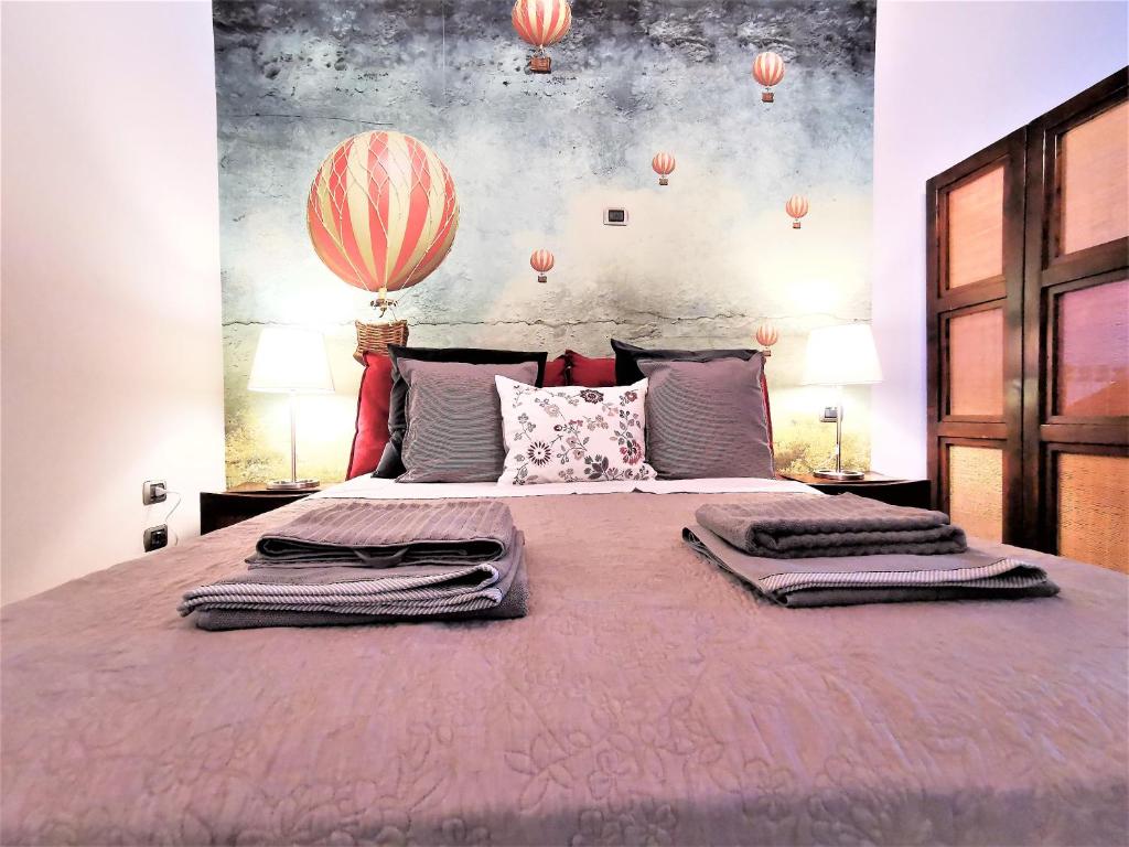 a bedroom with a large bed with two robes on it at Le mongolfiere in Lucca
