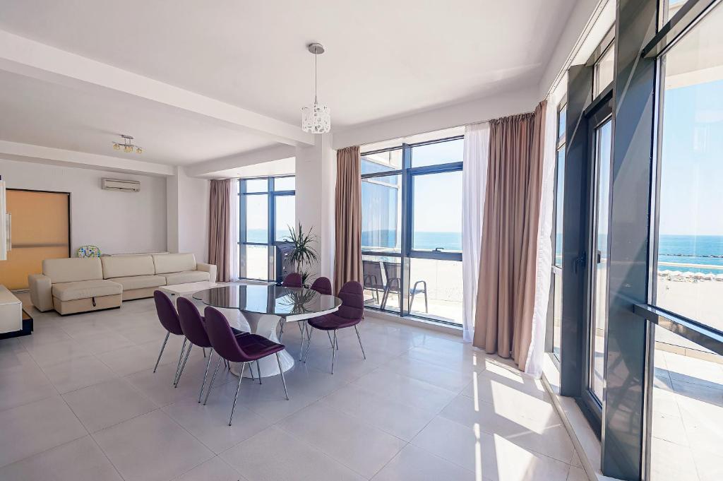 a living room with a glass table and chairs at Riviera Residence Apartments in Mamaia