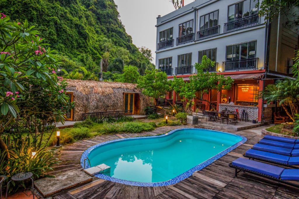 a swimming pool in a yard next to a building at Catba Backpackers Hostel & Pool Bar in Cat Ba