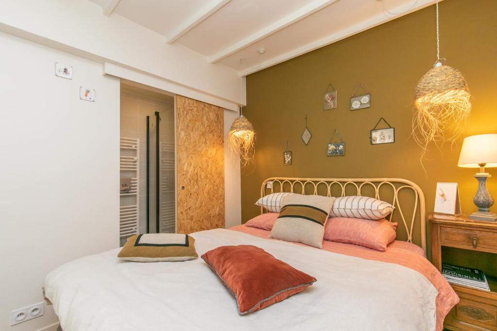 a bedroom with two beds with pillows at Maison du Saule in Fontenay-sous-Bois