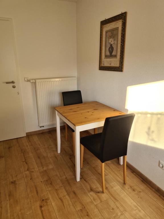 - une table en bois et 2 chaises dans une chambre dans l'établissement Holly's Home, à Bad Homburg vor der Höhe