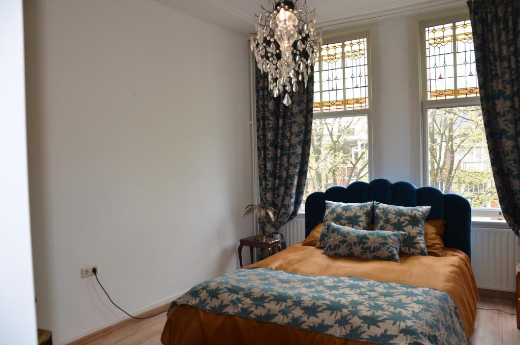 a bedroom with a bed and a chandelier at Huize Maurits in The Hague