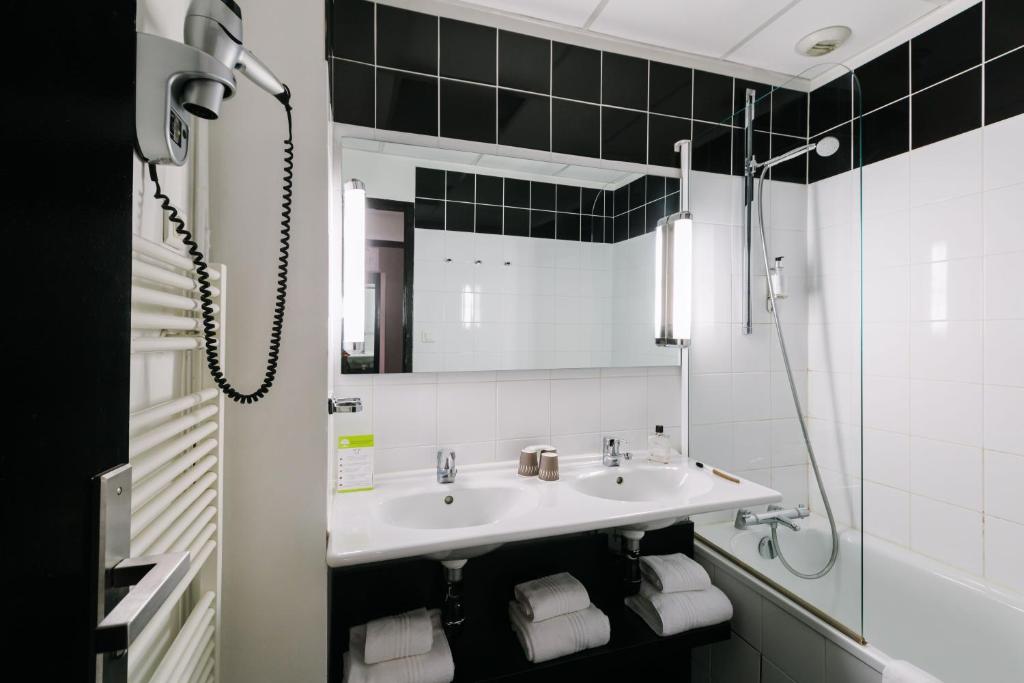 a bathroom with a sink and a mirror at Hôtel de Noailles in Lyon