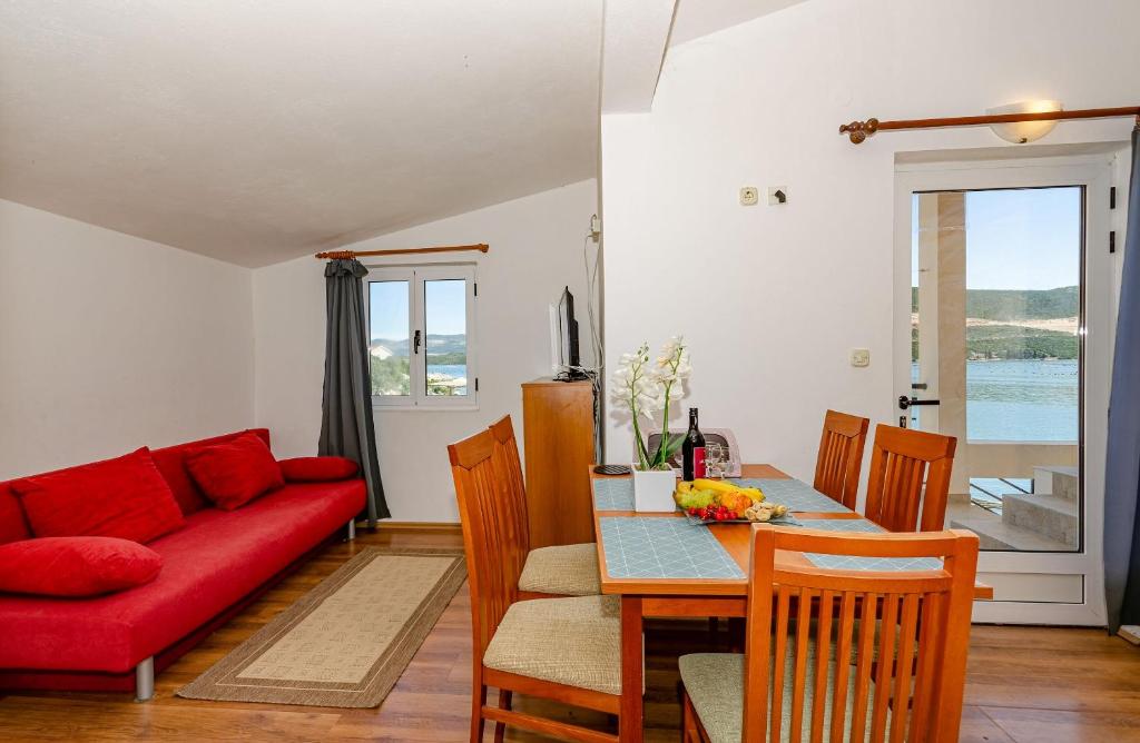 a living room with a red couch and a table at Apartments Oliver in Putniković