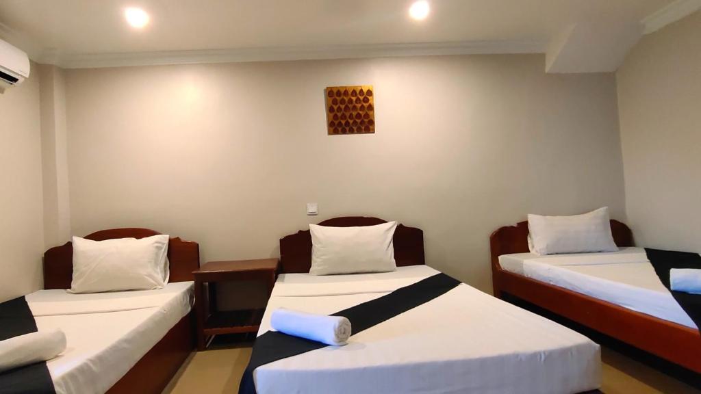 Cette chambre comprend 2 lits avec des draps blancs. dans l'établissement White Monkey, à Siem Reap