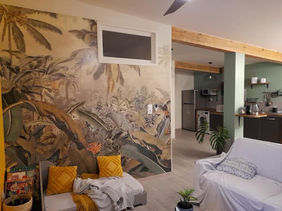 a living room with a wall with a mural at Le Farin la pluie by LONBRAZ VOLKAN in Saint-Philippe