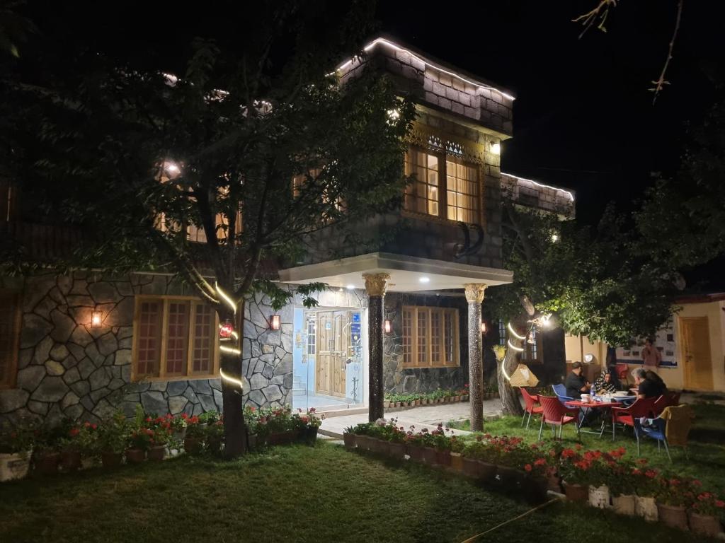 une maison la nuit avec des personnes assises à une table dans l'établissement Sehrish Guest House Skardu, à Skardu