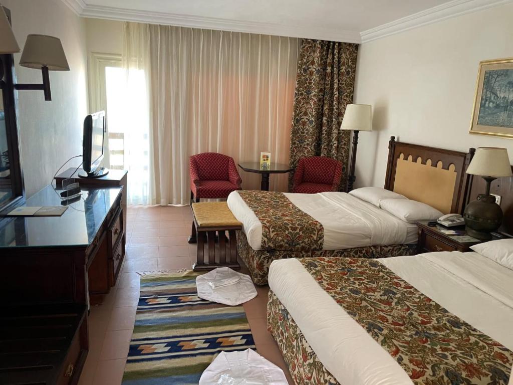 Cette chambre comprend deux lits et une télévision. dans l'établissement Retac El Arish, à El Arish