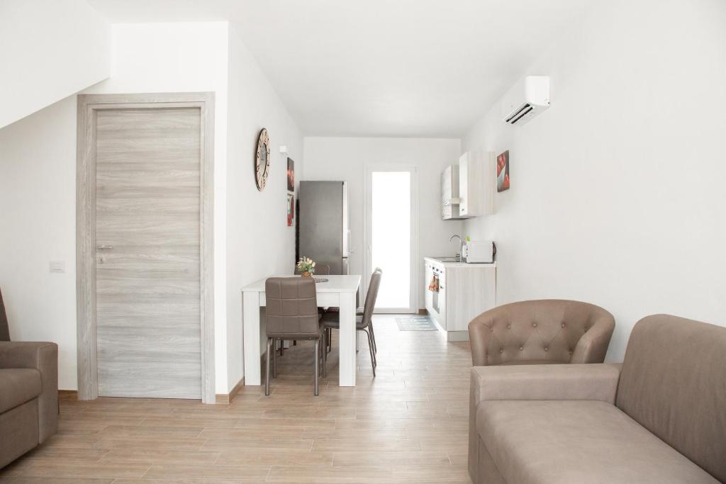 Pula Residence - Via Delle Rose في بولا: غرفة معيشة ومطبخ مع طاولة وكراسي