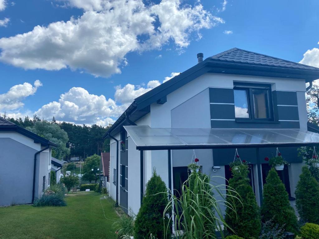 a blue and white house with a yard at Wiejska 21 in Ruciane-Nida