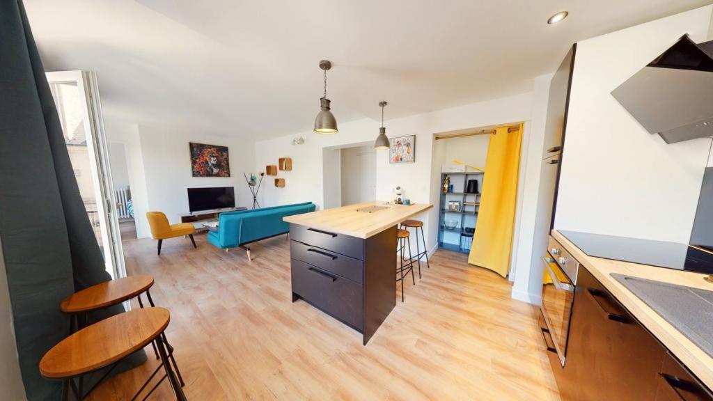 una cucina e un soggiorno con tavolo e sedie di Superbe appartement au cœur du centre ville a Caen