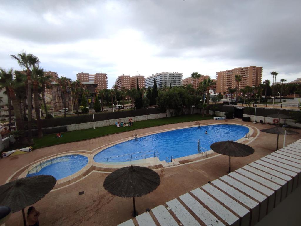 duży basen z parasolami w mieście w obiekcie Apartamento LAIA w mieście Oropesa del Mar