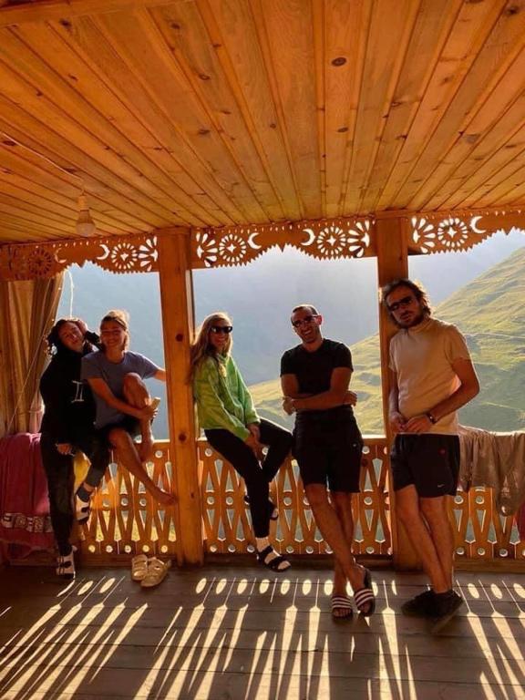 a group of people sitting on a wooden balcony at Guesthouse Kvavlo in Kvavlo